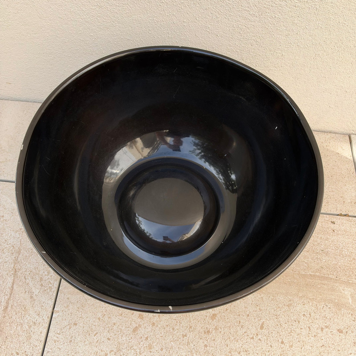 Side profile of black lacquered Moet Chandon champagne ice bucket with stepped base