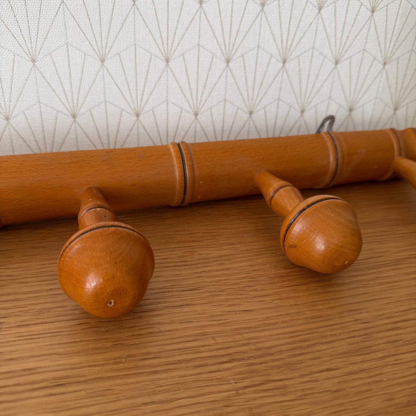 Side view of vintage French bamboo coat rack displaying natural wood finish and joinery
