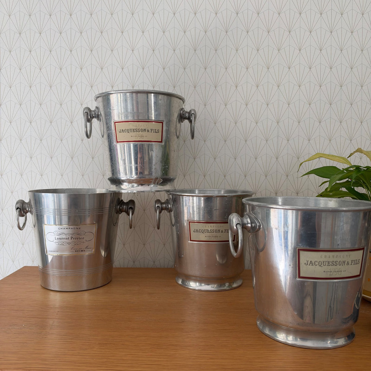 Four vintage French champagne ice buckets with Jacquesson and Laurent Perrier labels displayed together
