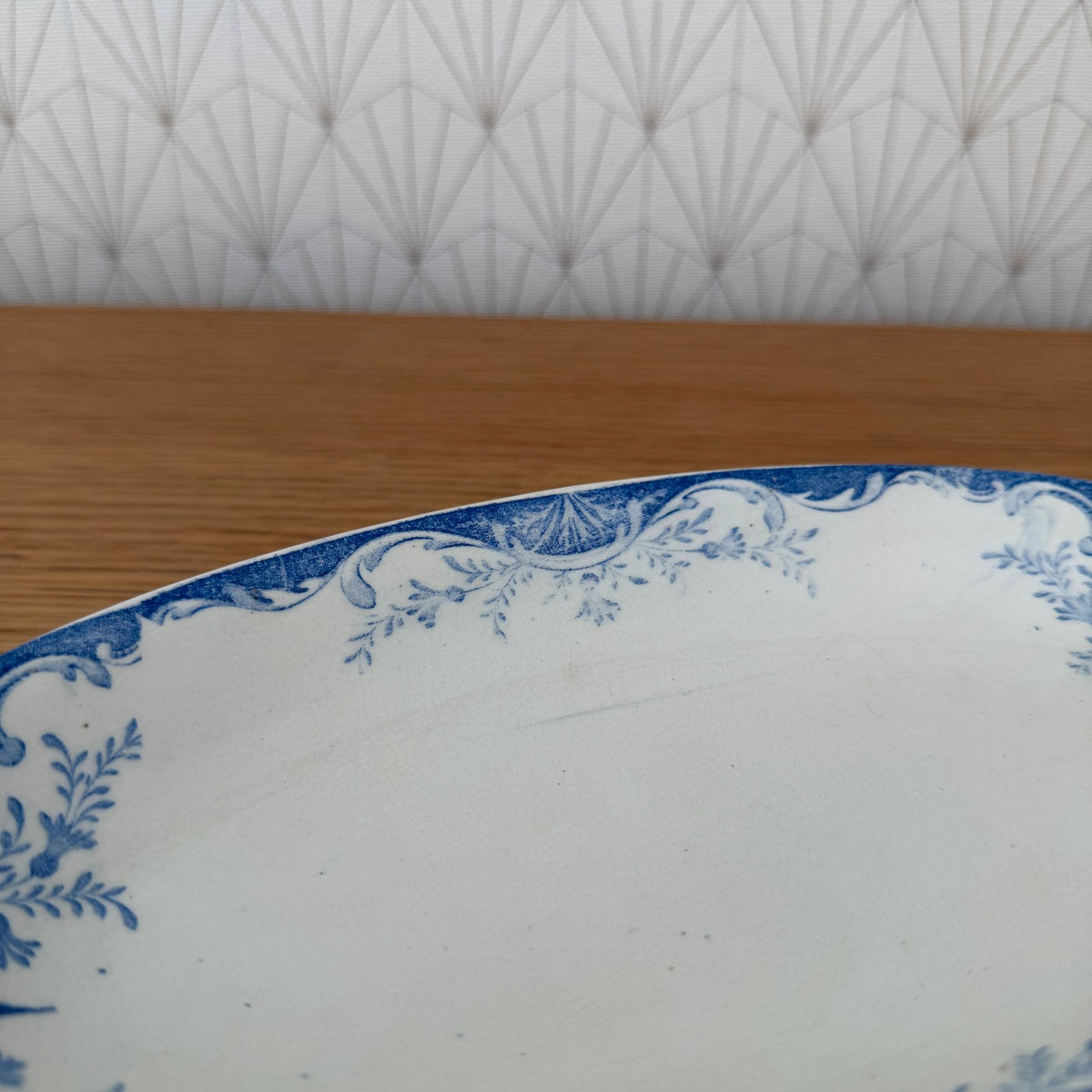 Close-up of the blue transfer-print border featuring scrolling acanthus leaves and shell motifs