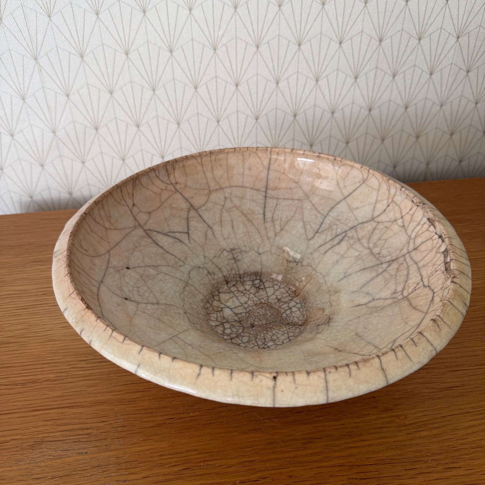 French ceramic crackle bowl from above, displaying extensive web-like brown crackle network across pale glaze surface