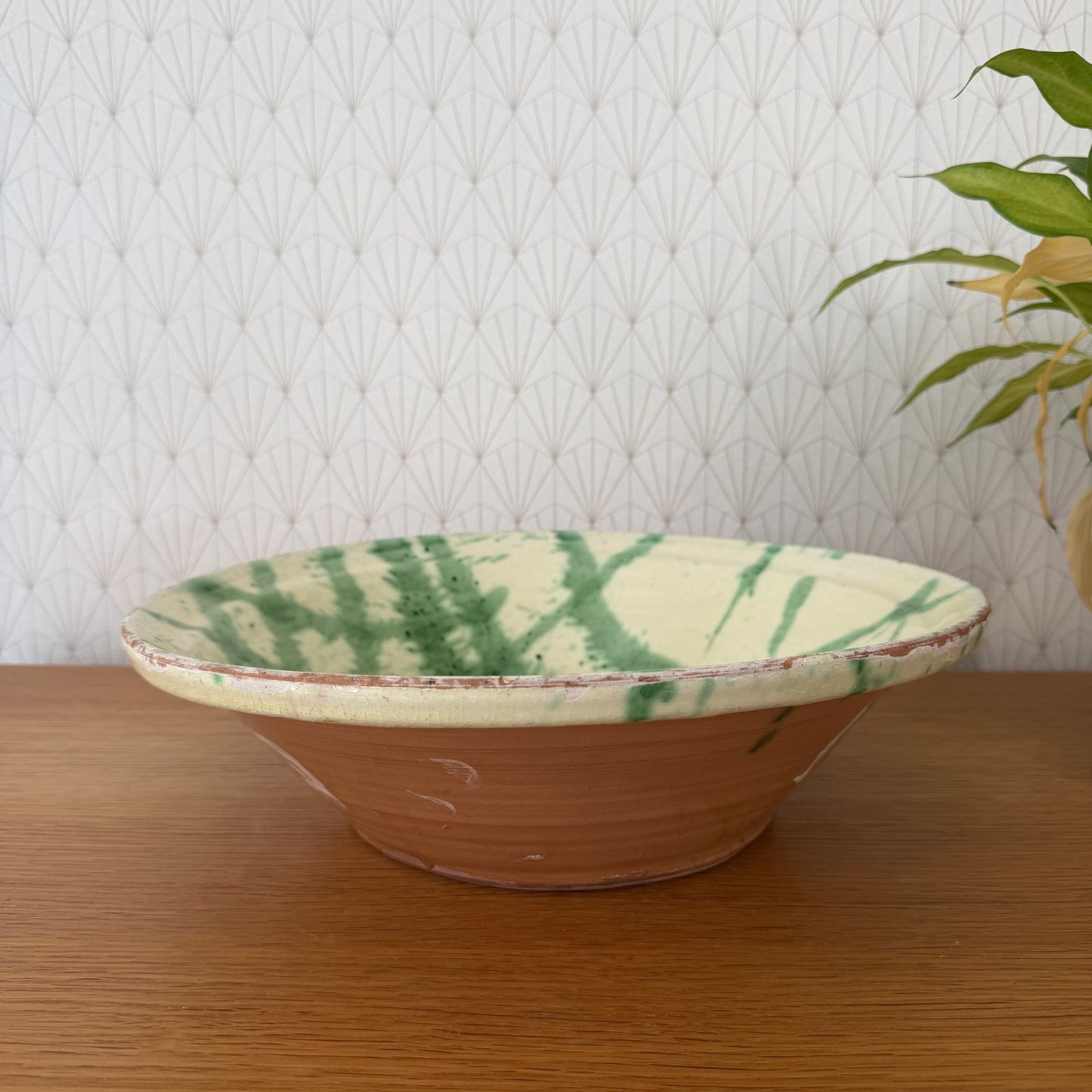 Vintage French glazed terracotta tian bowl with cream and green decoration, side view