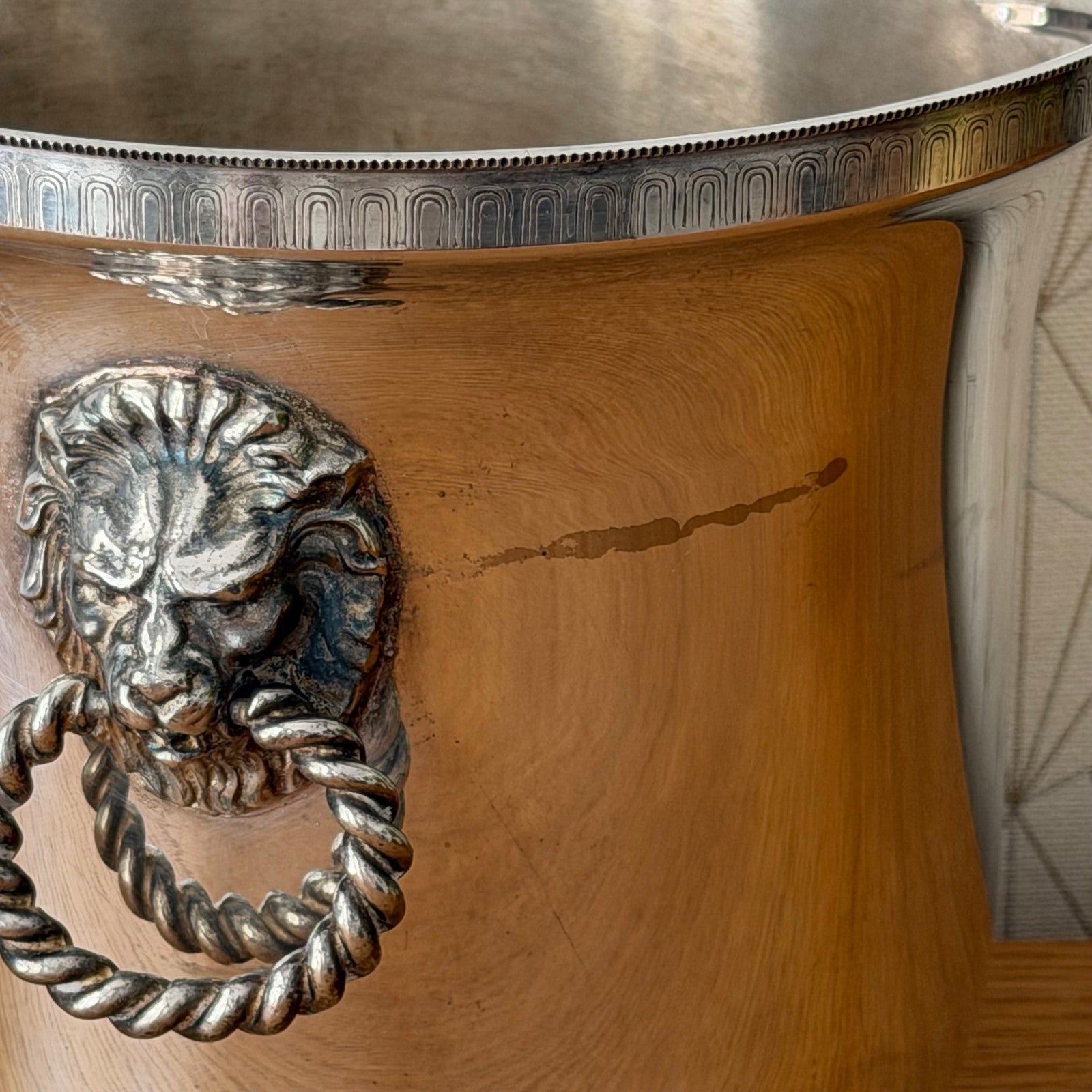 Close-up of ornate silvered lion handle on vintage French wine bucket