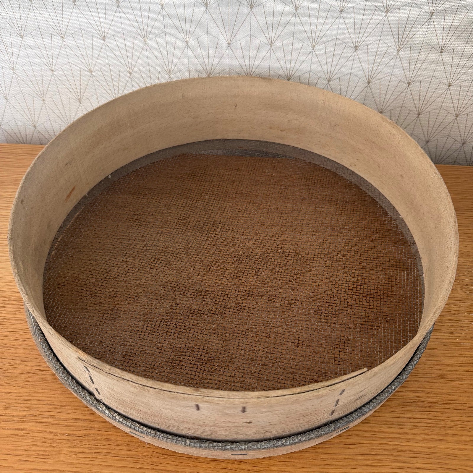 Full profile of vintage French bentwood flour sieve on wooden table