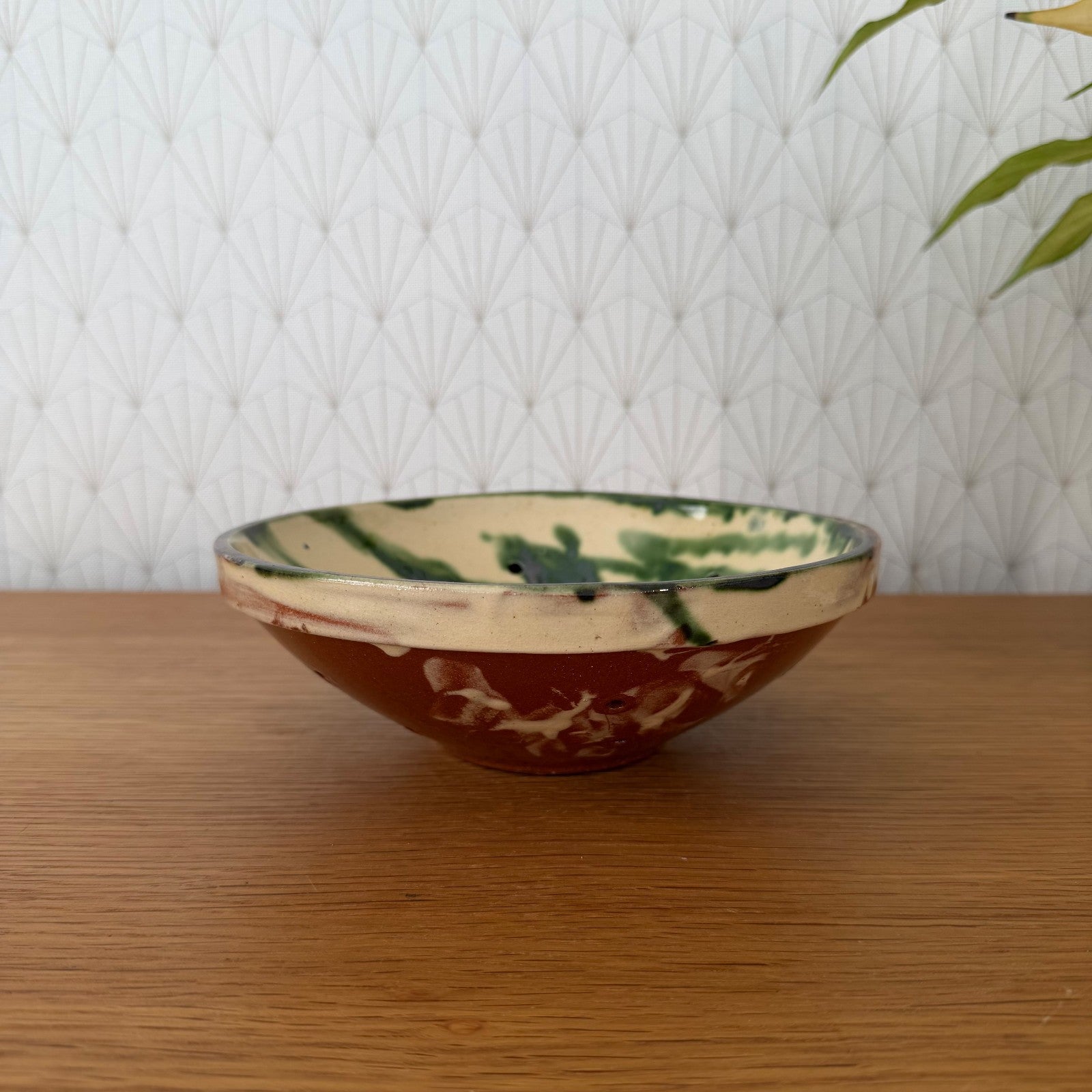 Vintage French pottery fruit colander bowl with cream interior and terracotta exterior, side view