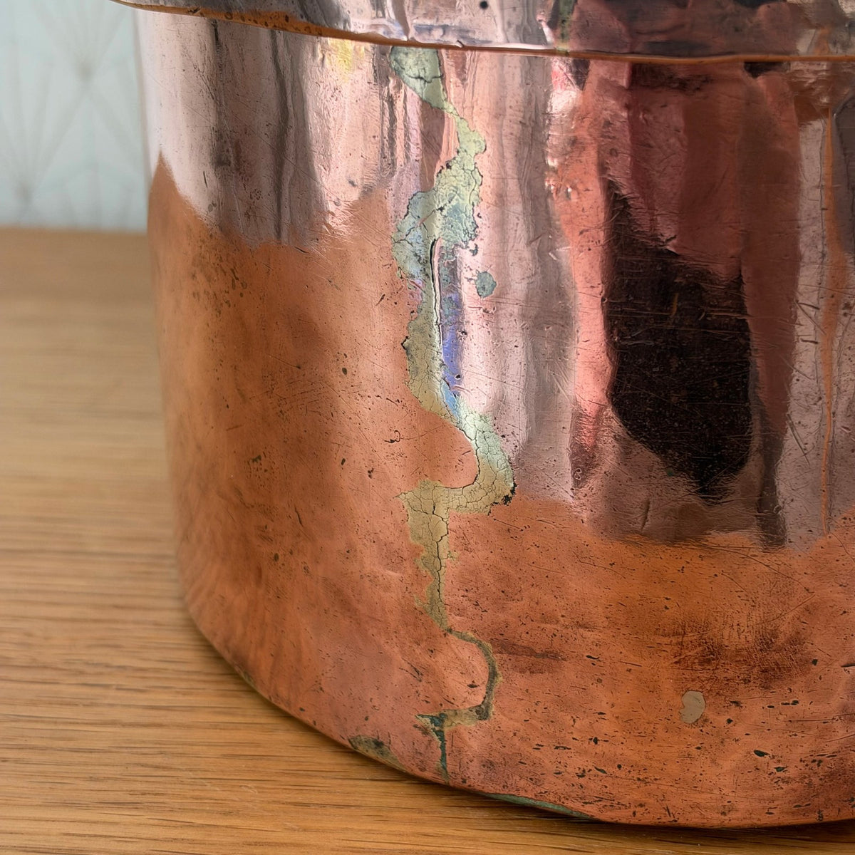 Side profile of antique dovetailed copper braising pan showing patina and seam construction