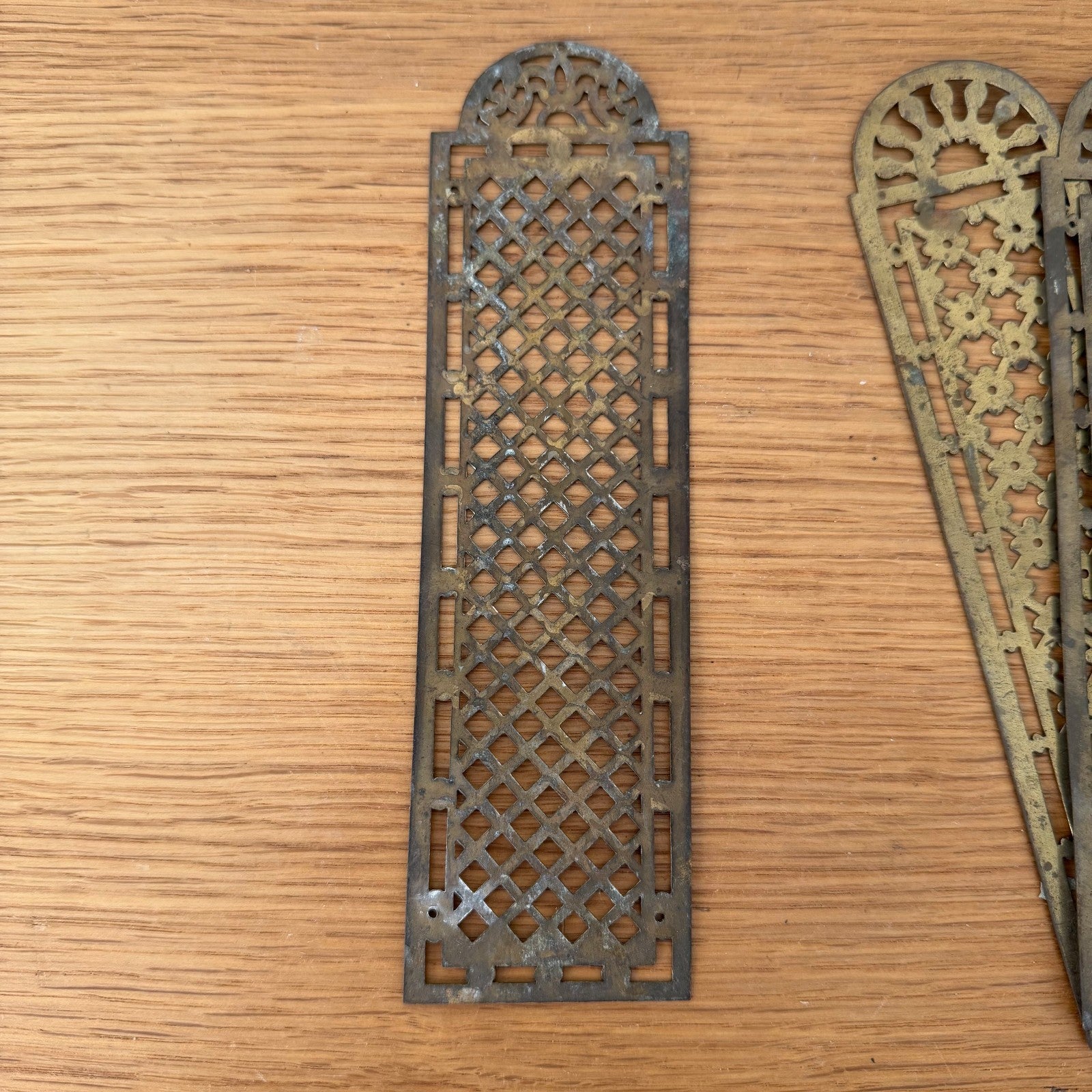 Close-up detail of pierced French vintage door plate with geometric diamond lattice pattern