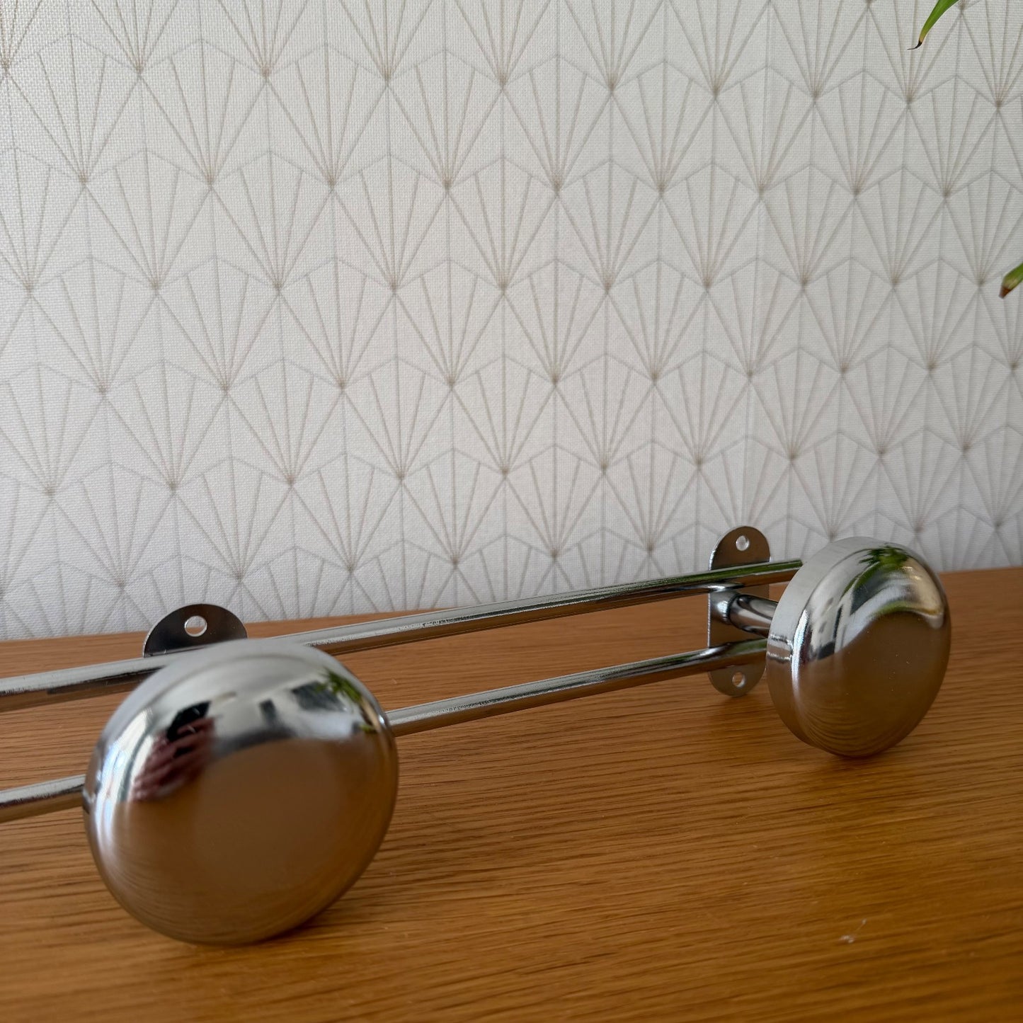Close-up angle of vintage French chrome hooks showing mirror-like finish and mounting brackets