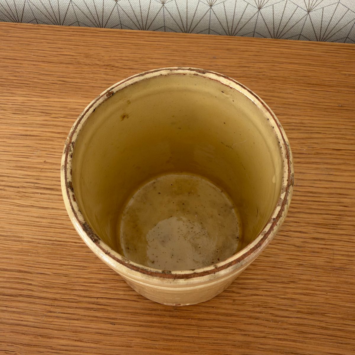 Top view looking down into antique French yellow glazed stoneware jam pot showing interior glaze and aged terracotta rim.