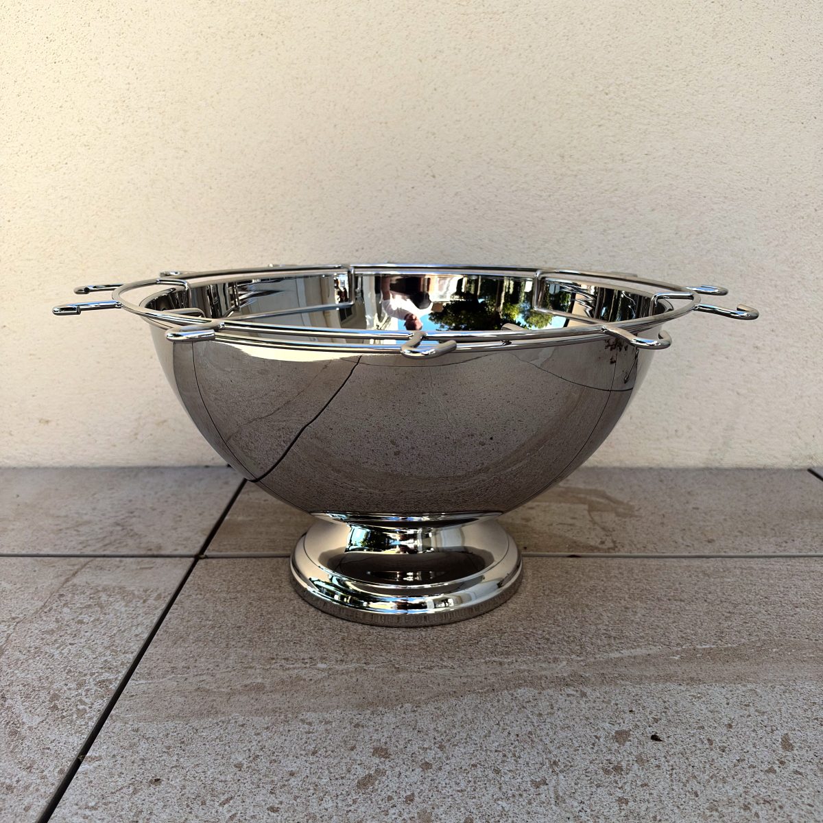 Guy Degrenne Aphrodite stainless steel champagne punch bowl with wire flute holder rack and pedestal base, side view, French barware.
