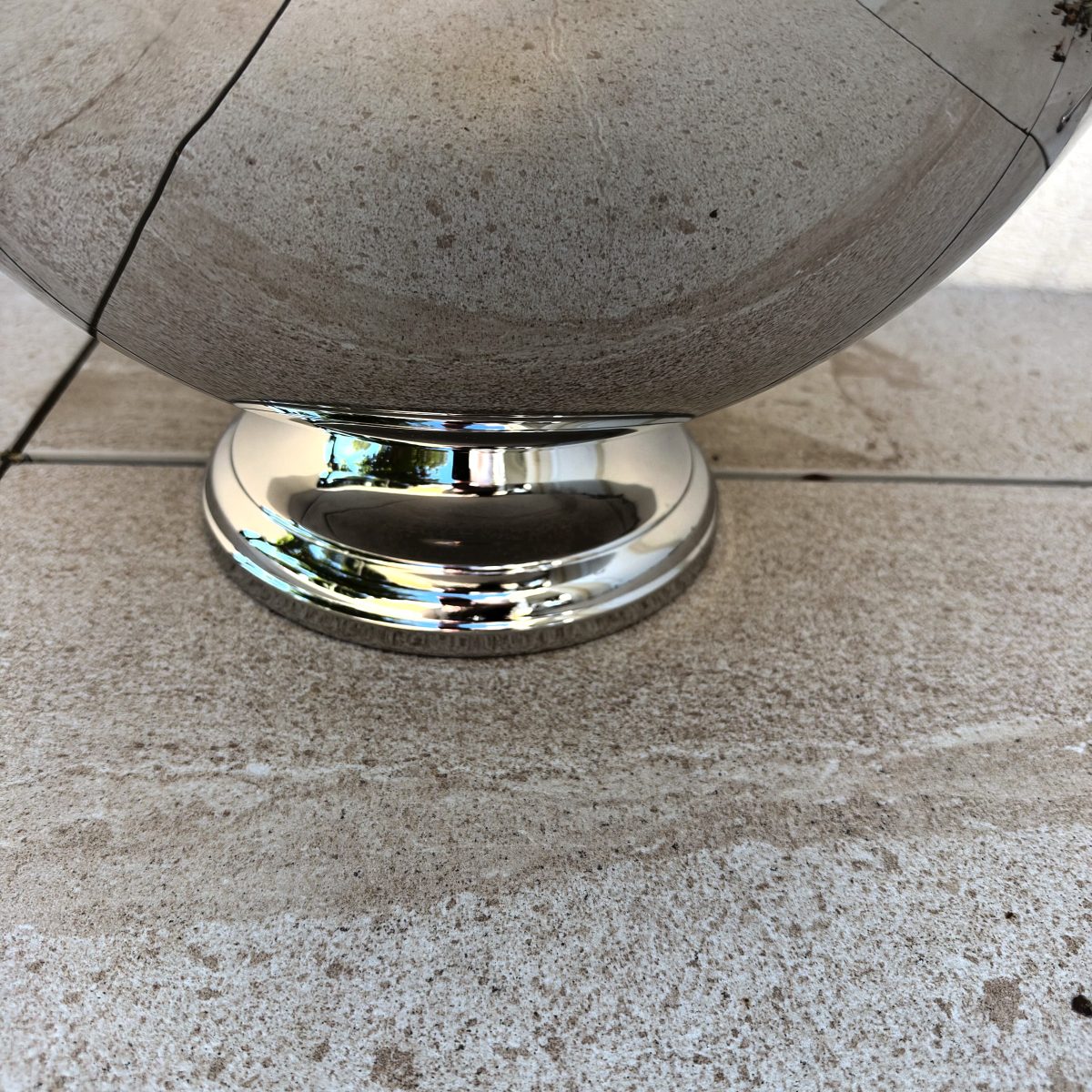 Close-up of the pedestal base of the Guy Degrenne Aphrodite stainless punch bowl, showing the polished stepped foot.