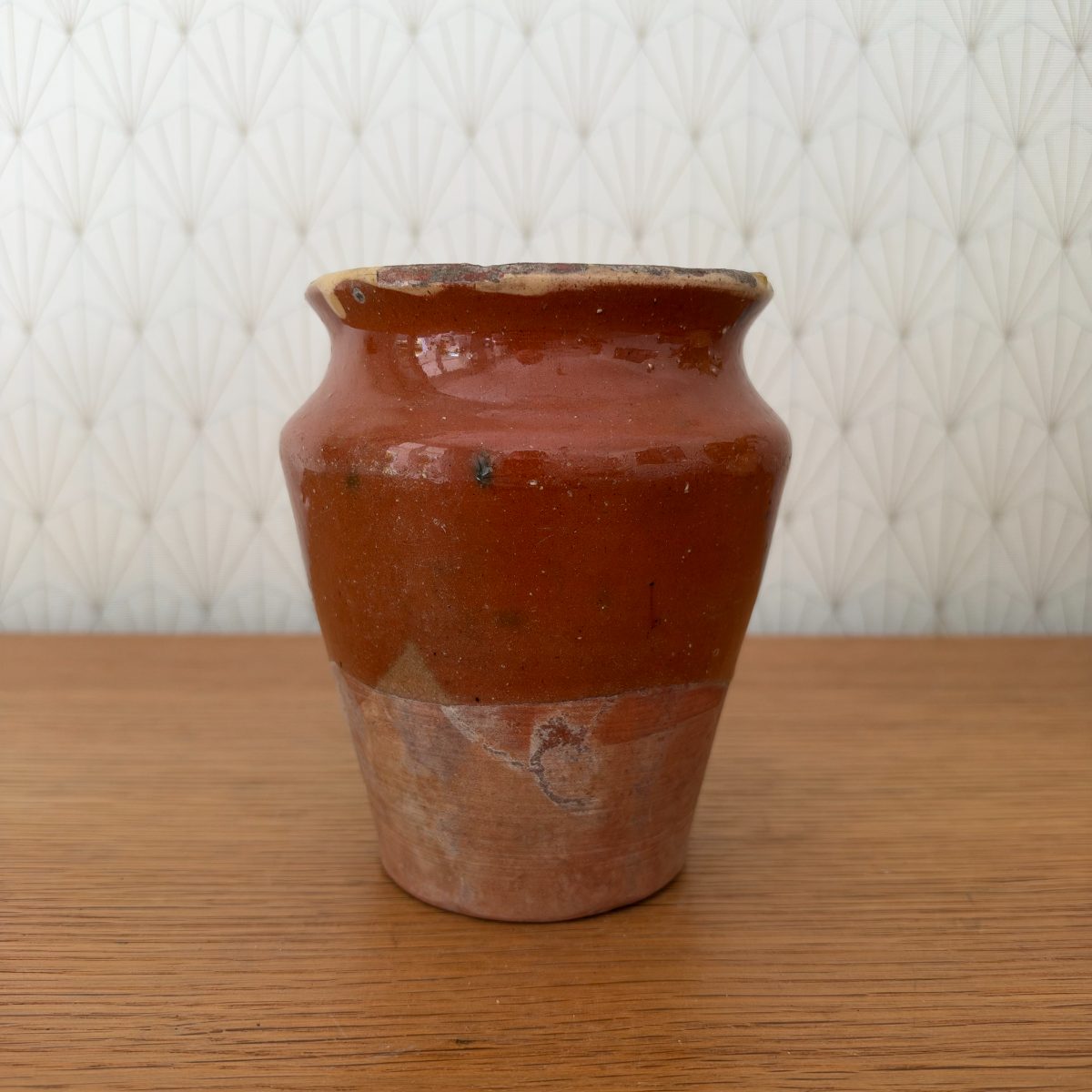 Opposite side of antique French earthenware pot showing full red-brown glaze coverage on upper body and natural terracotta at base.
