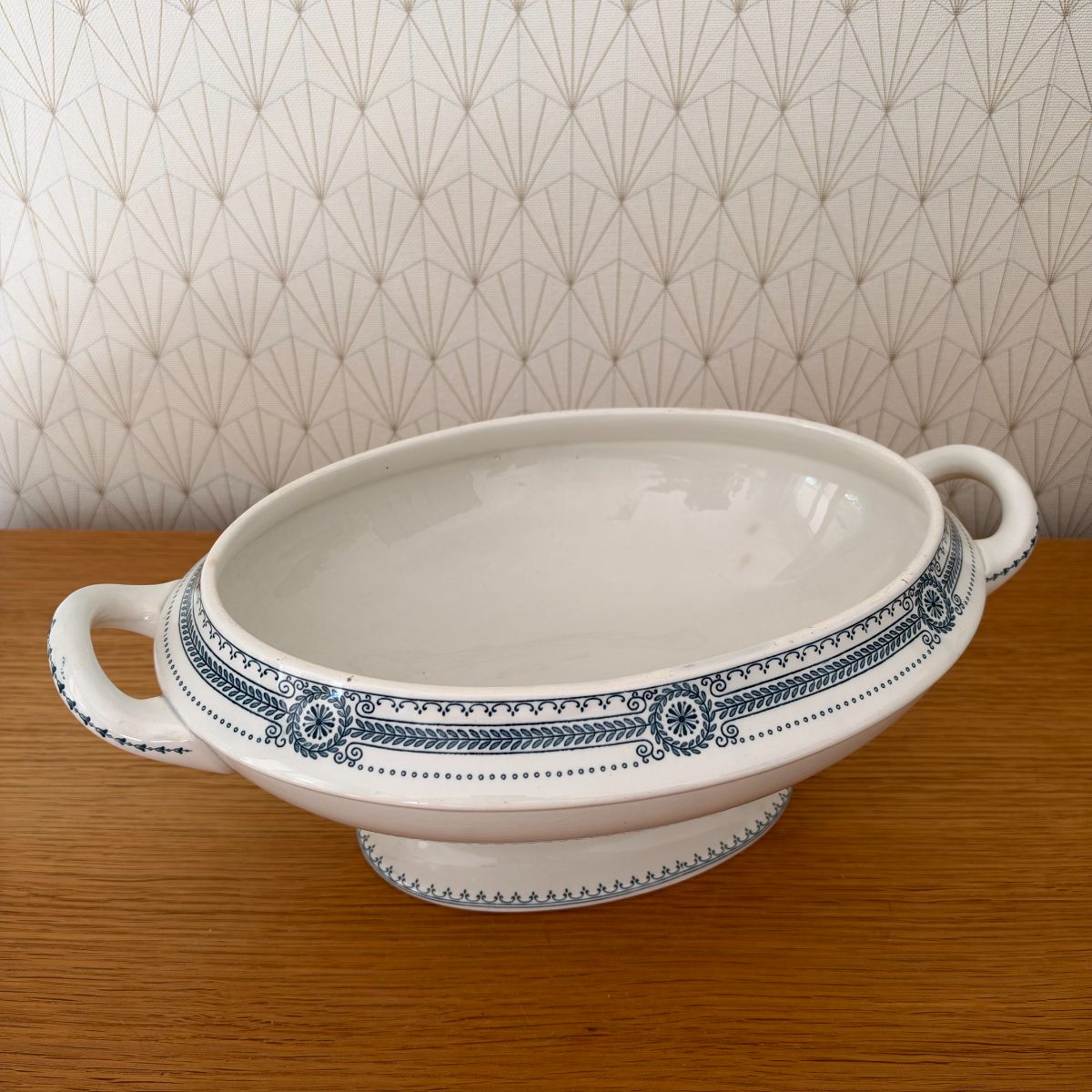 Antique French ironstone tureen base viewed from front, showing blue transferware laurel and medallion border, double handles, oval pedestal foot.