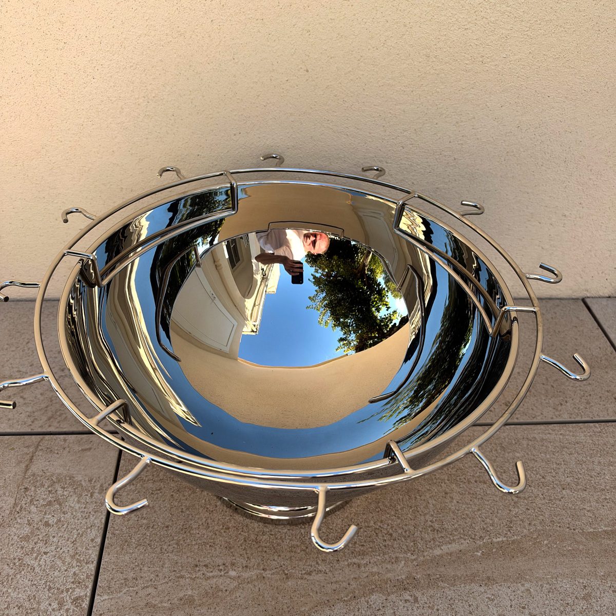 Top-down view of Guy Degrenne Aphrodite punch bowl showing the circular wire flute rack and the mirror-polished interior.