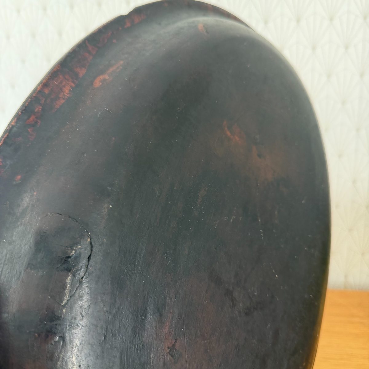 Close-up of the unglazed dark base of the French terracotta oval baking dish showing a small old firing crack.