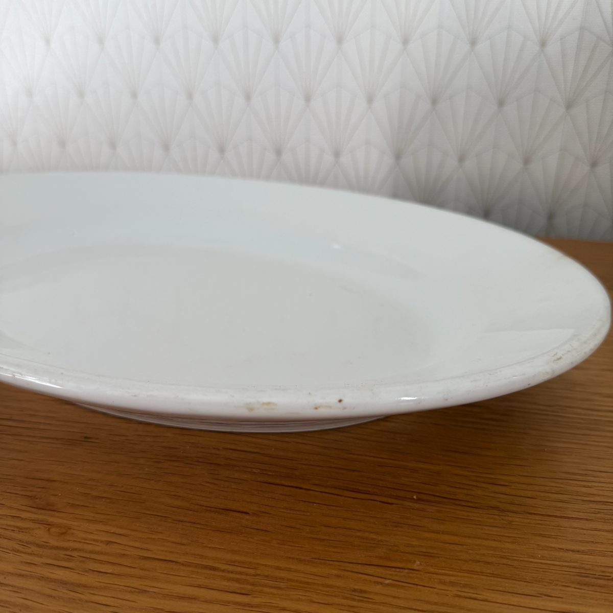 Close-up of rim and foot ring on antique French white ironstone oval platter showing light wear and age marks.