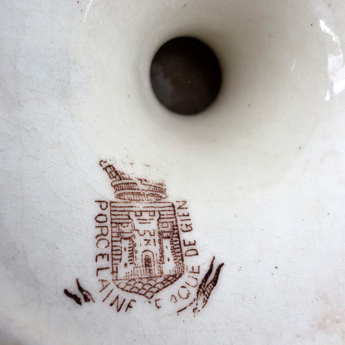 Close-up of the base stamp on the Gien pedestal cake stand reading Porcelaine Opaque de Gien with a castle mark.