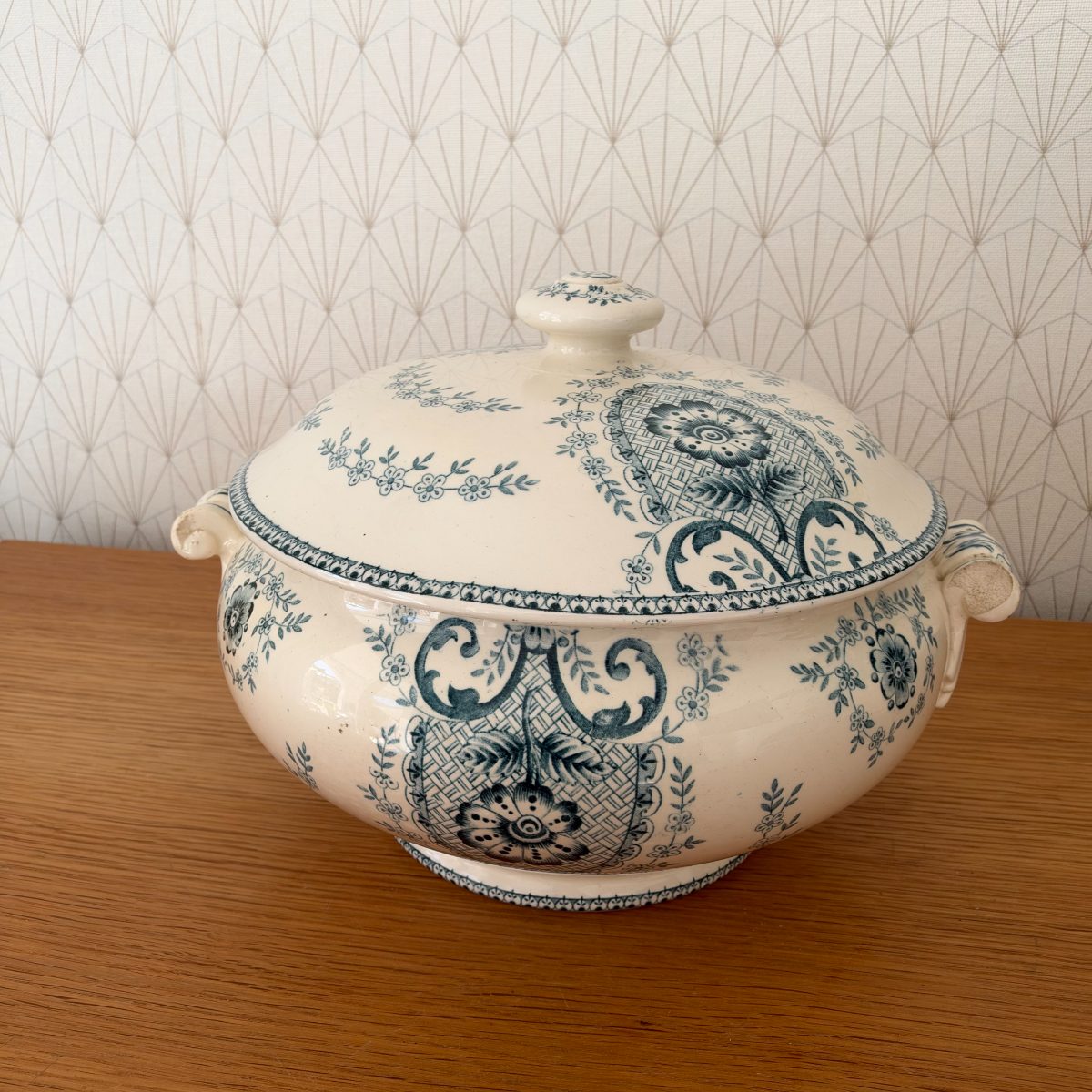 Antique French blue white transferware soup tureen with lid, three-quarter view showing floral medallion and lattice pattern on cream faience body.