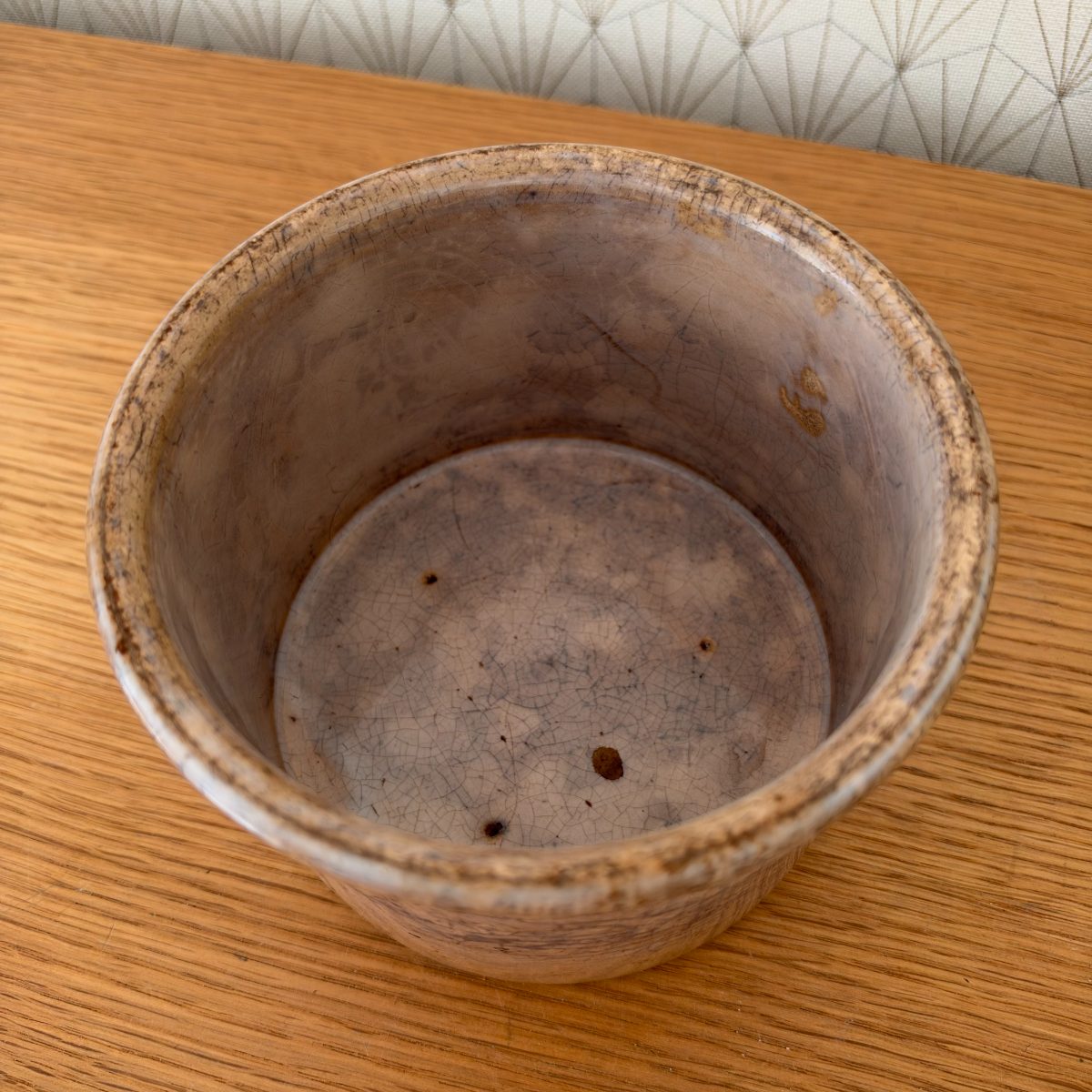 Top-down interior view of antique French Sarreguemines stoneware crock showing crazing and mottled glaze inside.